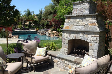 Custom swimming pool, lawn, outdoor fireplace and stone patio