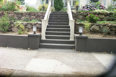 Design ideas for a mid-sized traditional partial sun front yard concrete paver retaining wall landscape in Portland.