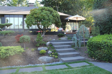Design ideas for a mid-sized traditional partial sun backyard concrete paver landscaping in Portland.