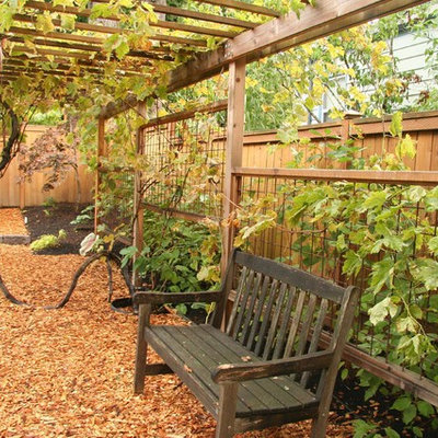 This is an example of a mid-sized traditional backyard stone landscaping in Portland.
