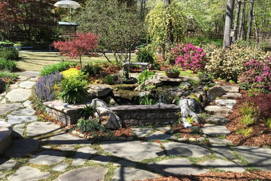 Photo of a large traditional partial sun backyard stone water fountain landscape in Raleigh.
