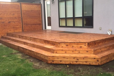 Inspiration for a mid-sized traditional backyard landscaping in Calgary with decking.