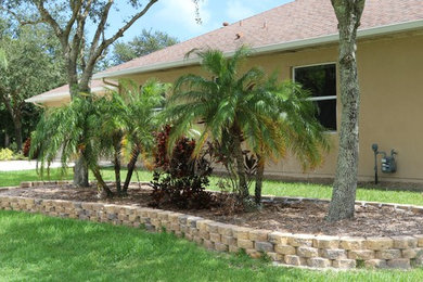 Photo of a small traditional partial sun front yard concrete paver retaining wall landscape in Orlando.