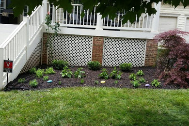 Photo of a mid-sized traditional partial sun front yard mulch formal garden in DC Metro for summer.