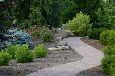 Design ideas for a large traditional partial sun backyard stone landscaping in St Louis for summer.