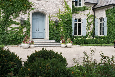 This is an example of a large french country full sun front yard driveway in Chicago.