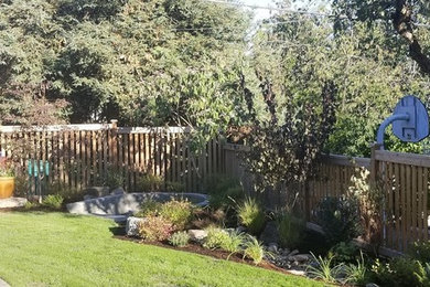 Ejemplo de jardín tradicional de tamaño medio en verano en patio trasero con brasero, exposición total al sol y gravilla