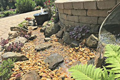 Cette image montre un petit xéropaysage arrière rustique l'été avec un point d'eau, une exposition ensoleillée et des pavés en brique.