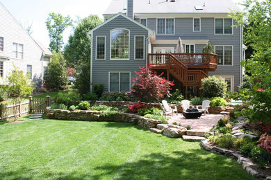 Photo of a large traditional partial sun backyard stone landscaping in DC Metro for spring.