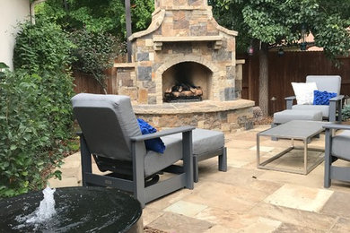 Inspiration for a mid-sized timeless backyard stone patio remodel in Denver with a fireplace