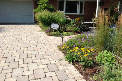 Medium sized front driveway full sun garden in Chicago with concrete paving.
