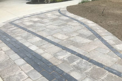 Photo of a small contemporary brick driveway in Detroit.