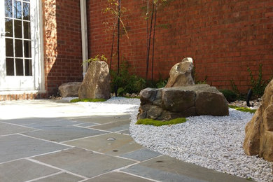 На фото: маленький тенистый регулярный сад на заднем дворе в восточном стиле с садовой дорожкой или калиткой и покрытием из каменной брусчатки для на участке и в саду с