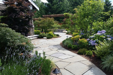 Imagen de jardín de estilo americano en patio trasero con adoquines de piedra natural