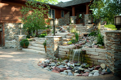 Ejemplo de jardín contemporáneo grande en patio trasero con fuente, exposición total al sol y adoquines de piedra natural