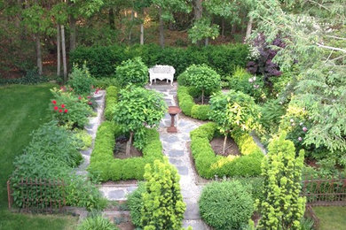 Modelo de jardín tradicional renovado grande en primavera en patio trasero con jardín francés, fuente, exposición parcial al sol y adoquines de piedra natural