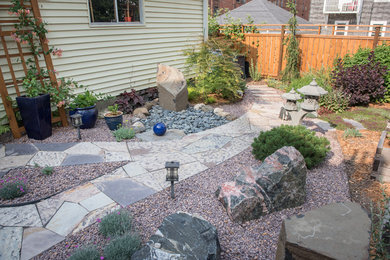 Photo of a mid-sized asian full sun backyard stone landscaping in Milwaukee for summer.