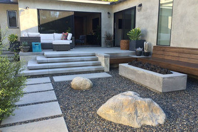 Photo of a large modern drought-tolerant and shade backyard gravel landscaping in Los Angeles with a fire pit.