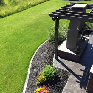 Großer Garten hinter dem Haus mit Kamin und Mulch in Calgary