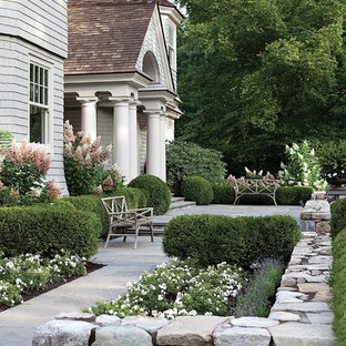 Idées déco pour un jardin à la française avant classique de taille moyenne et l'été avec des pavés en pierre naturelle, une exposition ensoleillée et un massif de fleurs.