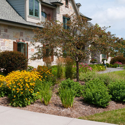 This is an example of a mid-sized traditional full sun front yard concrete paver landscaping in Milwaukee for summer.