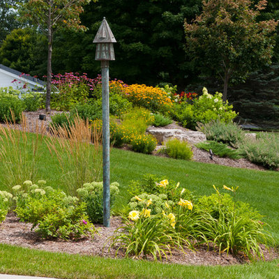 Design ideas for a mid-sized traditional full sun front yard stone retaining wall landscape in Milwaukee for summer.