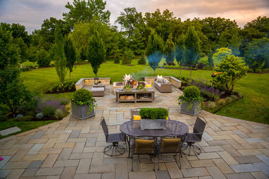 Example of a huge transitional backyard stone patio design in Chicago