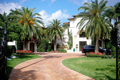 Design ideas for a large tropical front yard brick driveway in Miami.