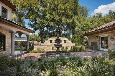 Esempio di un piccolo giardino formale american style esposto in pieno sole davanti casa in estate con fontane e pavimentazioni in mattoni
