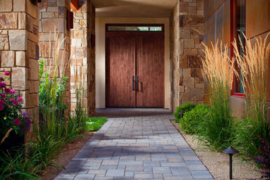 This is an example of a small contemporary front formal garden in Denver with a garden path and natural stone paving.