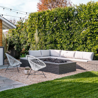 Esempio di un giardino moderno dietro casa con un focolare e ghiaia