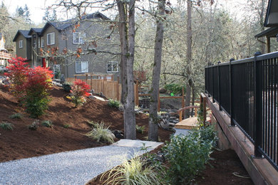 This is an example of a large traditional hillside mulch landscaping in Other for winter.