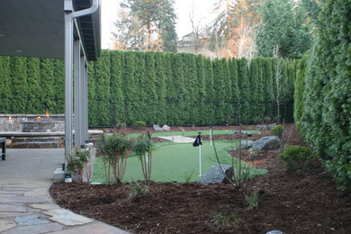 Photo of a mid-sized traditional partial sun backyard stone outdoor sport court in Other for winter.