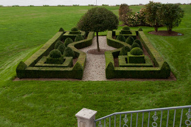 Aménagement d'un grand jardin à la française arrière classique l'été avec une exposition ensoleillée.