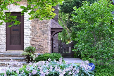 На фото: большой летний регулярный сад на боковом дворе в классическом стиле с садовой дорожкой или калиткой, полуденной тенью и покрытием из каменной брусчатки с