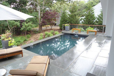 Pool - large traditional backyard brick pool idea in Boston