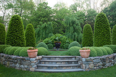 Immagine di un giardino formale classico esposto in pieno sole con scale