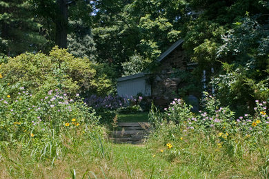 Inspiration för en liten lantlig trädgård i full sol som tål torka och i slänt på sommaren, med en trädgårdsgång och naturstensplattor
