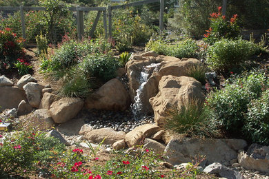 Foto di un grande giardino chic esposto in pieno sole dietro casa in estate con fontane