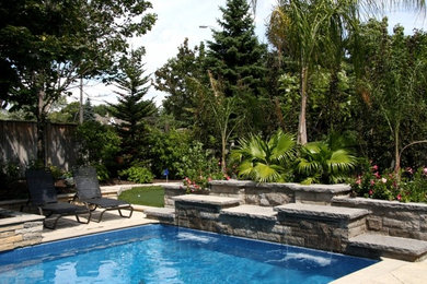 Photo of a tropical backyard stone water fountain landscape in Toronto.