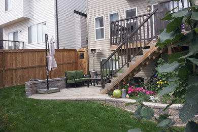 Photo of a traditional partial sun concrete paver retaining wall landscape in Calgary.
