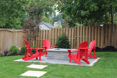This is an example of a large traditional full sun backyard concrete paver landscaping in Toronto with a fire pit.