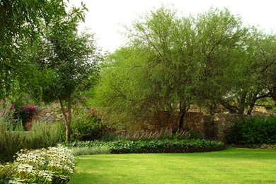 Imagen de jardín mediterráneo en patio lateral con jardín francés y exposición parcial al sol