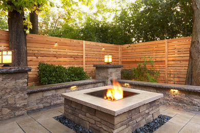 Design ideas for a large contemporary backyard stone landscaping in New York with a fire pit.
