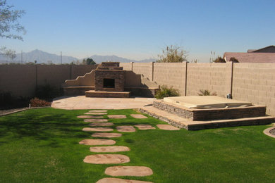 This is an example of a large full sun backyard stone landscaping in Phoenix with a fire pit for summer.