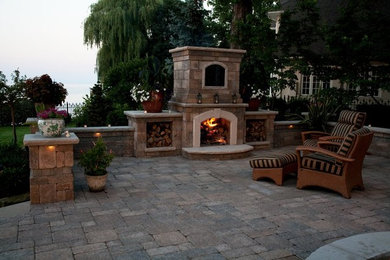 Example of a mid-sized backyard stone patio design in Cleveland with a fire pit