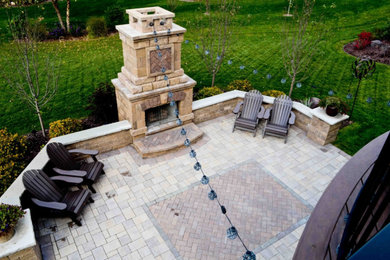 Inspiration for a mid-sized timeless backyard brick patio remodel in Minneapolis with a fireplace