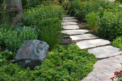 Photo of a traditional backyard brick garden path in Chicago.
