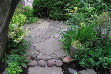 Photo of a small contemporary full sun backyard stone landscaping in Portland.