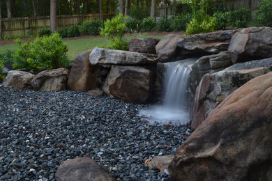 Photo of a mid-sized contemporary partial sun backyard water fountain landscape in Atlanta for summer.
